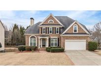 Brick two-story house with a large front yard, driveway, and attached garage at 2678 Bonaire Ter, Marietta, GA 30066