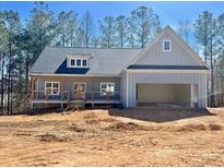 New home boasts a charming exterior with a spacious garage, and inviting front porch at 85 Presley Farm Pkwy, Rockmart, GA 30153