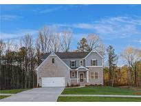 Two-story home with gray siding, brick accents, and a three-car garage at 508 Dolce Rd, Locust Grove, GA 30248