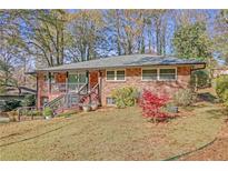 Brick ranch house with a landscaped yard and attached deck at 2289 Montrose Dr, East Point, GA 30344