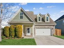 Two-story house with green siding, brick accents, and a two-car garage at 100 Orchard Ln, Covington, GA 30014