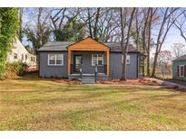 Charming gray house with wood accents and a well-manicured lawn at 1534 Alma Sw St, Atlanta, GA 30311