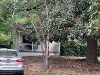 Cute yellow house with front porch, surrounded by lush greenery at 1914 Bragg St, Brookhaven, GA 30341