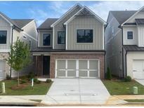 Charming two-story home with a brick-accented facade and white garage doors in a modern style at 1070 Crest Mill Dr, Marietta, GA 30008