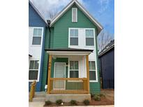 Charming two-story home with a covered front porch and a striking green exterior at 1095 Tucker Ave # 408, Atlanta, GA 30310