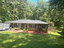 Charming brick ranch-style home with a well-manicured lawn and mature trees at 6625 Starling Sw Pl, Mableton, GA 30126