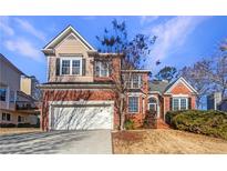 Brick two-story house with a large attached garage and manicured lawn at 3905 Colonial Sw Trl, Lilburn, GA 30047