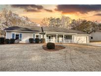 Ranch home with front porch, attached garage, and well-manicured lawn at 758 Shoreline Se Trl, Conyers, GA 30094