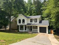 Charming two-story home with a manicured lawn, black windows, black door and an attached garage at 1126 Williamsburg Ln, Norcross, GA 30093
