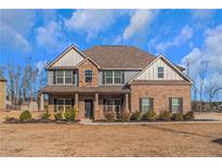 Two-story brick home with gray siding, a large front porch, and a landscaped yard at 149 Elkins Blvd, Locust Grove, GA 30248