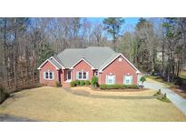 Brick home with gray roof, large yard, and long driveway at 3648 Clark Hill Way, Buford, GA 30519