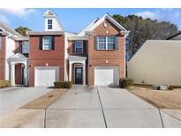 Brick front exterior of townhome with 2-car garage and landscaping at 1246 Adcox Sq, Stone Mountain, GA 30088