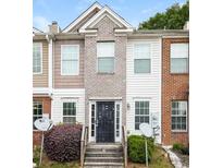 Brick townhouse exterior with a black metal front door and small landscaping at 2852 Vining Ridge Ter, Decatur, GA 30034