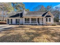 Ranch style home with white siding, front porch, and mature landscaping at 4620 Sammy Dr, Powder Springs, GA 30127