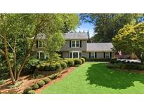 Two-story house with a well-manicured lawn and mature trees at 1130 Edgewater Dr, Atlanta, GA 30328