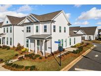 Charming two-story white home with manicured front yard landscaping and covered entryway, on a sunny corner lot at 1026 Cagle Creek Overlook, Canton, GA 30115