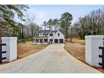 Stunning two-story white home with a long driveway and well-manicured front yard at 467 Concord Sw Rd, Smyrna, GA 30082