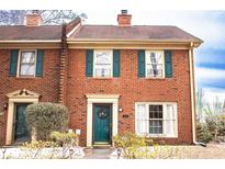 Brick front exterior of charming townhome with teal door and landscaping at 6136 Winfield Ct, Tucker, GA 30084