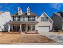 Two story house with beige siding, stone accents, and a two car garage at 2839 Suttonwood Way, Buford, GA 30519