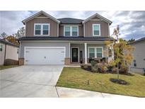 Charming two-story home featuring a two-car garage, a welcoming front porch and manicured landscaping at 419 Murphy Ave, Canton, GA 30114