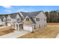 Two-story home with gray siding, brick accents, and a two-car garage at 13958 Conrad Court Ln, Covington, GA 30014