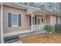 Inviting exterior with a covered porch and well-maintained landscaping at 2374 Rolling Acres Sw Dr, Conyers, GA 30094