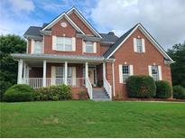 Brick two-story house with a front porch and landscaped lawn at 100 Meadow Lake Dr, Carrollton, GA 30116