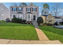 Updated two-story townhome with a manicured lawn at 1042 Plantation Nw Way, Kennesaw, GA 30144