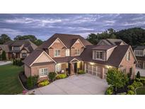 Brick two-story home with a three-car garage and landscaped front yard at 109 Slate Dr, Buford, GA 30518