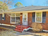 Brick ranch house with a red front steps, grey shutters and a well-maintained lawn at 5548 Alder Dr, Forest Park, GA 30297