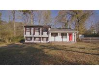 Two-story home with white siding, brown shutters, red door, and a well-maintained front lawn at 2500 Celina Ct, Morrow, GA 30260