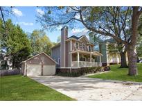 Two-story house with a wraparound porch, attached garage, and manicured lawn at 109 Bowen Sw Cir, Atlanta, GA 30315