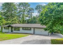 White brick ranch house with attached garage and large yard at 1322 S Hicks Nw Cir, Conyers, GA 30012