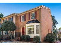 Brick townhouse with red door, shutters, and bay window at 2027 Raleigh Tavern Dr, Roswell, GA 30076