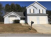 Two-story house with gray siding, a two-car garage, and a neatly landscaped lawn at 5332 Shirewick Dr, Lithonia, GA 30058