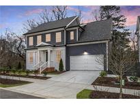 Charming two-story home with a well-manicured lawn, a driveway, and an attached two-car garage at 386 10Th Unit 57 St, Auburn, GA 30011