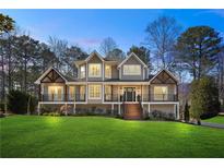 Charming two-story home with a landscaped yard, wooden porch and stairs, and black railings at 3051 Maple Ln, Alpharetta, GA 30009