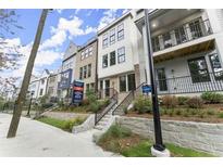 Modern townhouses with brick and white siding, steps leading to the entrance, and landscaping at 1773 Beckham Ne Pl # 56, Atlanta, GA 30324