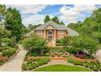 Brick home with landscaped yard and circular driveway at 619 Champions Dr, Mcdonough, GA 30253