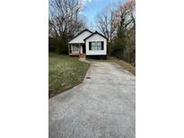 Charming home with a contrasting black and white color scheme, complemented by a well-maintained front yard and driveway at 1111 Osborne Sw St, Atlanta, GA 30310