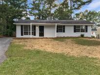 Cozy single-story home featuring black shutters, fresh mulch, and a well-maintained lawn at 9129 Bent Pine Ne Ct, Covington, GA 30014