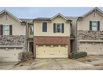 Charming townhouse featuring a brick facade and a convenient two-car garage at 162 Townview Dr, Woodstock, GA 30189