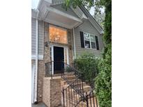 Inviting front entrance of home, featuring brick stairs, black railings, and a large window above the front door at 571 Oak Vista Ct, Lawrenceville, GA 30044