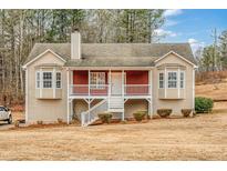 Beige house with red brick accents, a porch, and stairs leading to the entrance at 1785 Hampton Pass, Douglasville, GA 30134