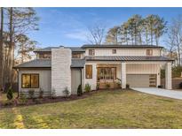 Stunning two-story home with metal roof, stone accents and landscaped lawn at 3099 Shadowood Ln, Marietta, GA 30066