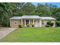 Newly renovated ranch home with a metal roof and landscaped lawn at 6945 Brown S Dr, Fairburn, GA 30213