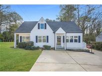 White charming house with gray roof, manicured lawn, and a long driveway at 1831 Dresden Dr, Brookhaven, GA 30319