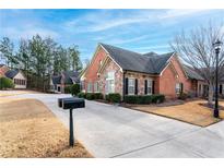 Brick townhouse exterior with driveway and landscaping at 2401 Brookhavenrun Cir, Duluth, GA 30097