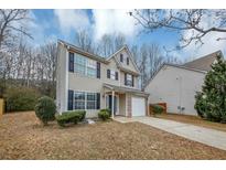 Two-story house with beige vinyl siding, black shutters, and a white garage door at 3542 Brookstone Way, Union City, GA 30291