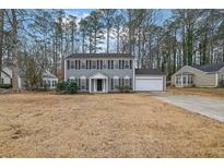 Two-story house with gray siding, attached garage, and manicured lawn at 1261 Parkwood Chase Nw, Acworth, GA 30102